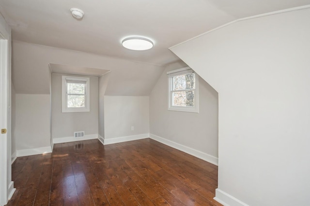 bonus room featuring hardwood / wood-style floors, a healthy amount of sunlight, visible vents, and baseboards