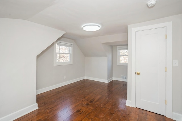 bonus room with visible vents, baseboards, a healthy amount of sunlight, and dark wood-style flooring