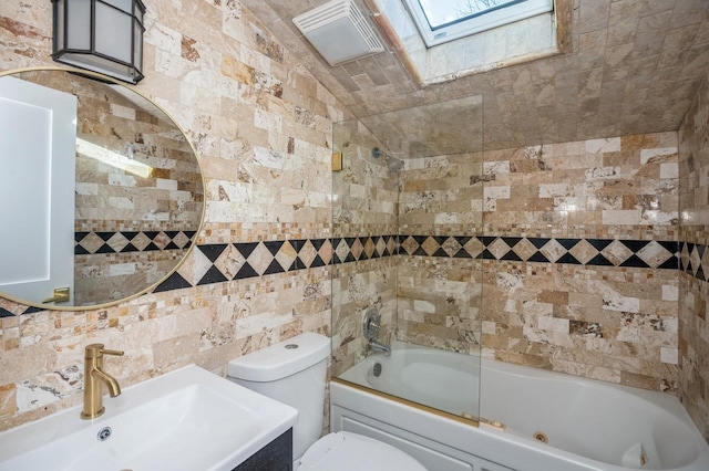 full bath with toilet, a sink, tile walls, a skylight, and tub / shower combination