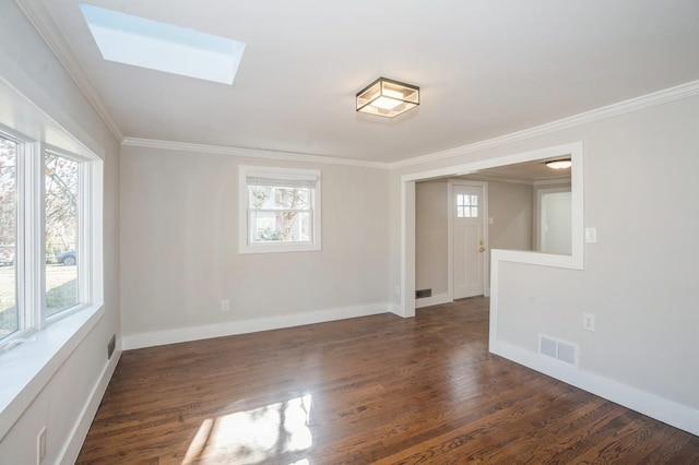 empty room with visible vents, plenty of natural light, dark wood-type flooring, and a skylight