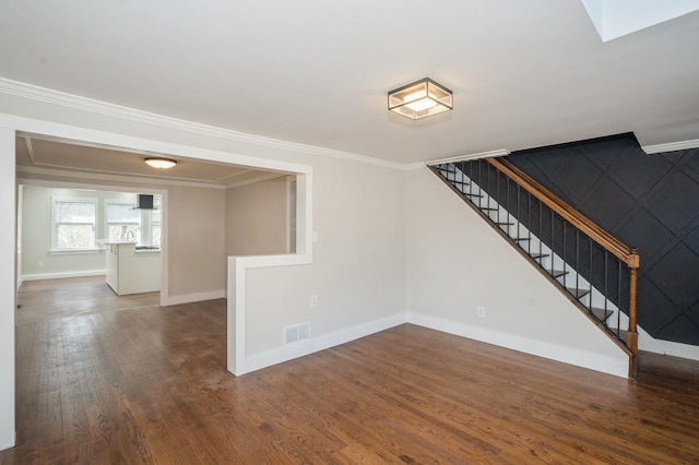 interior space with visible vents, baseboards, stairway, ornamental molding, and wood finished floors