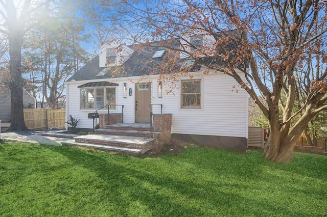 view of front of home with a front lawn and fence