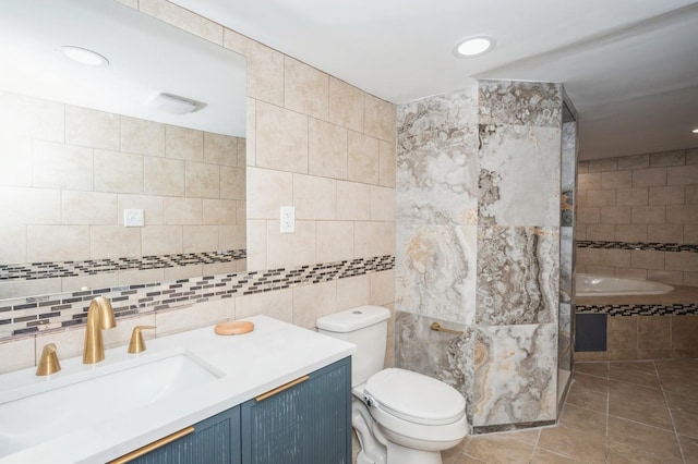 bathroom featuring tile patterned flooring, tile walls, toilet, and vanity