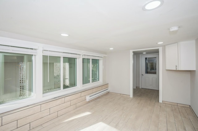 spare room featuring recessed lighting, baseboard heating, and light wood finished floors