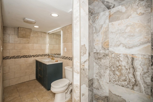 bathroom with toilet, recessed lighting, tile walls, tile patterned flooring, and vanity