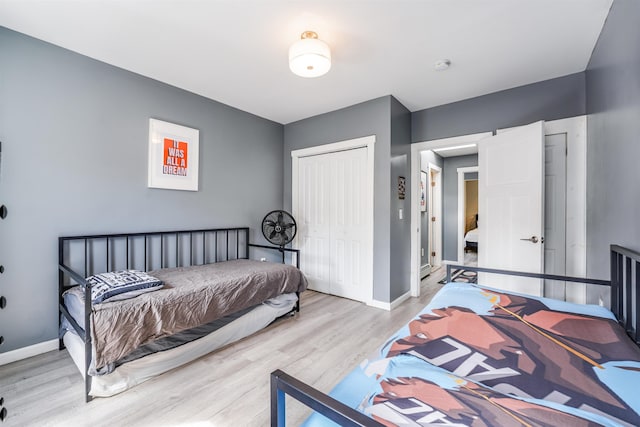 bedroom featuring a closet, baseboards, and wood finished floors