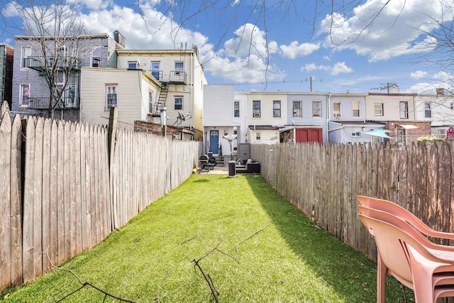 view of yard with a fenced backyard and a residential view