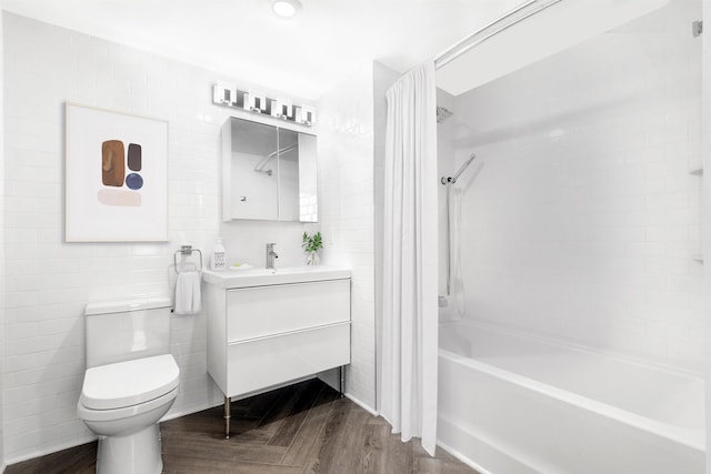 full bathroom featuring tile walls, shower / bathing tub combination, toilet, vanity, and wood finished floors