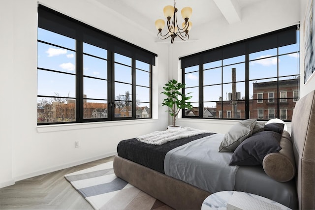 bedroom with a chandelier, beamed ceiling, and baseboards