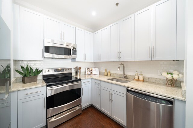 1500 Hudson St Unit 7U, Hoboken, NJ 07030 - kitchen featuring appliances with stainless steel finishes, a sink, backsplash, light stone counters, and white cabinets