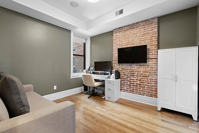 office space featuring baseboards, visible vents, and light wood finished floors