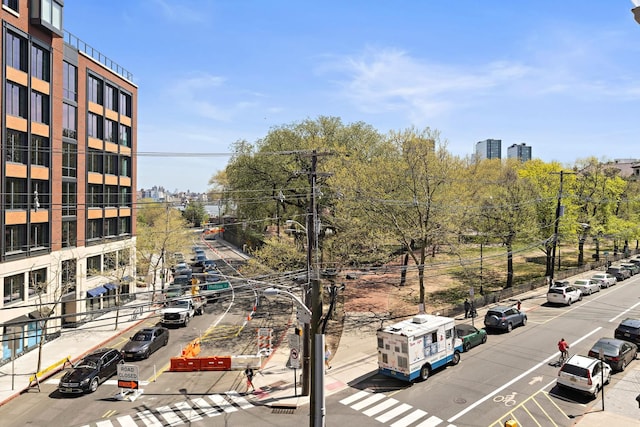 exterior space featuring street lighting, curbs, sidewalks, and a view of city