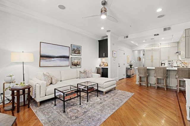 living area with a ceiling fan, visible vents, recessed lighting, and light wood finished floors