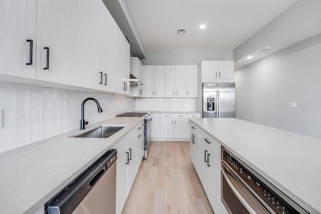 810 6th St Unit 2, Union City, NJ 07087 - kitchen with stainless steel appliances, light wood-style flooring, light countertops, backsplash, and white cabinetry