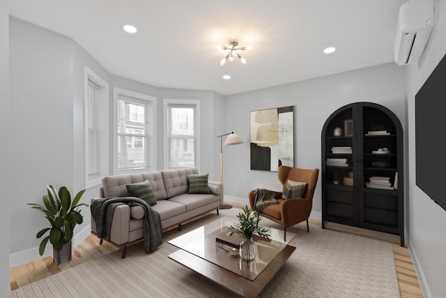 living room with a wall mounted AC, light wood-type flooring, and built in features