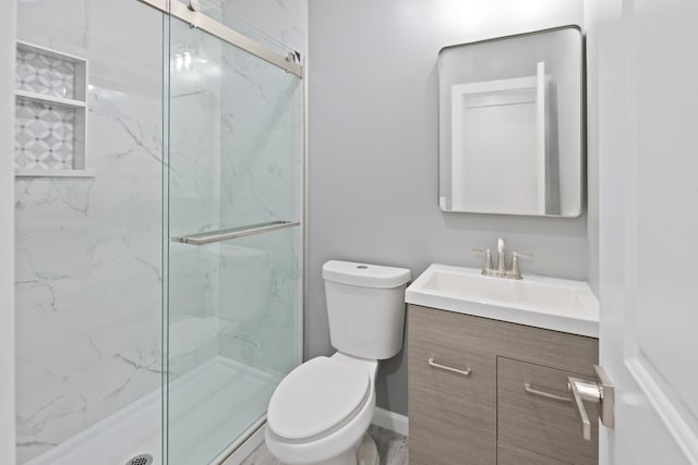 bathroom with toilet, an enclosed shower, and vanity