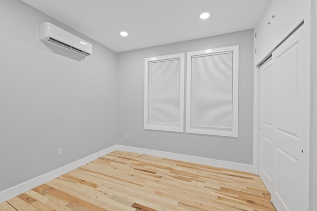 spare room with light hardwood / wood-style floors and a wall mounted AC