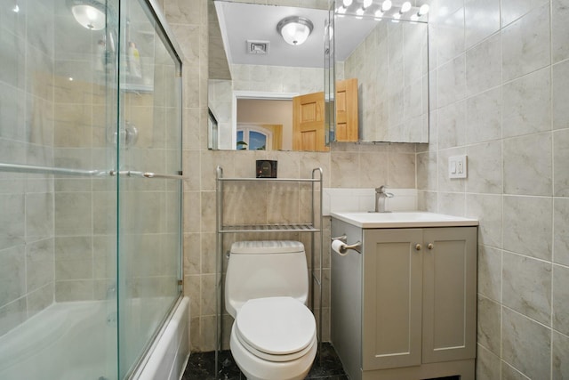 311 Palisade Ave Unit 3B, Jersey City, NJ 07307 - bathroom featuring tile walls, vanity, and bath / shower combo with glass door