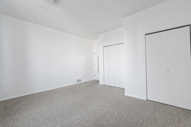 unfurnished bedroom with carpet, visible vents, and baseboards