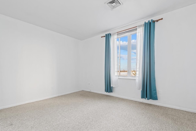 carpeted spare room featuring visible vents and baseboards