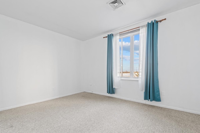 carpeted spare room featuring baseboards