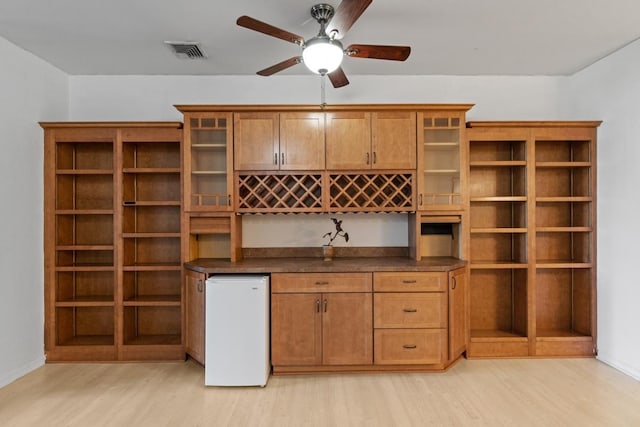 interior space featuring visible vents, ceiling fan, and light wood finished floors