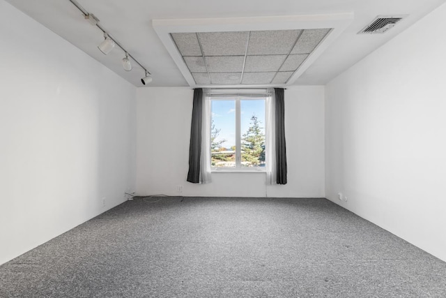 unfurnished room with carpet floors, rail lighting, and visible vents