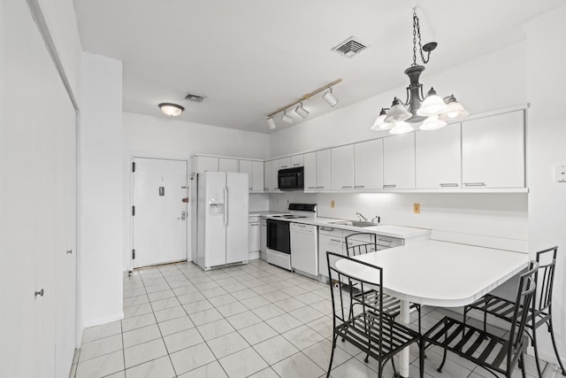 kitchen featuring white appliances, light countertops, a chandelier, pendant lighting, and a peninsula