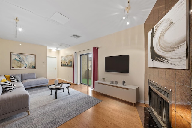 75 Liberty Ave Unit E13, Jersey City, NJ 07306 - living area featuring a tile fireplace, rail lighting, and light wood-type flooring