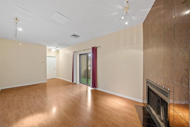 75 Liberty Ave Unit E13, Jersey City, NJ 07306 - unfurnished living room with a tile fireplace, track lighting, wood finished floors, and heating unit