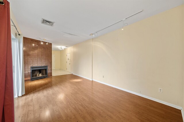 75 Liberty Ave Unit E13, Jersey City, NJ 07306 - unfurnished living room with track lighting, wood finished floors, and a fireplace