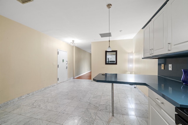 75 Liberty Ave Unit E13, Jersey City, NJ 07306 - kitchen with dark countertops, white cabinetry, and pendant lighting