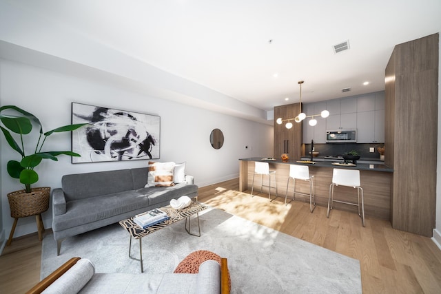 living room with sink and light wood-type flooring