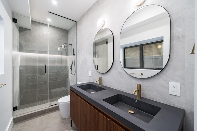 bathroom with toilet, an enclosed shower, tile walls, and vanity