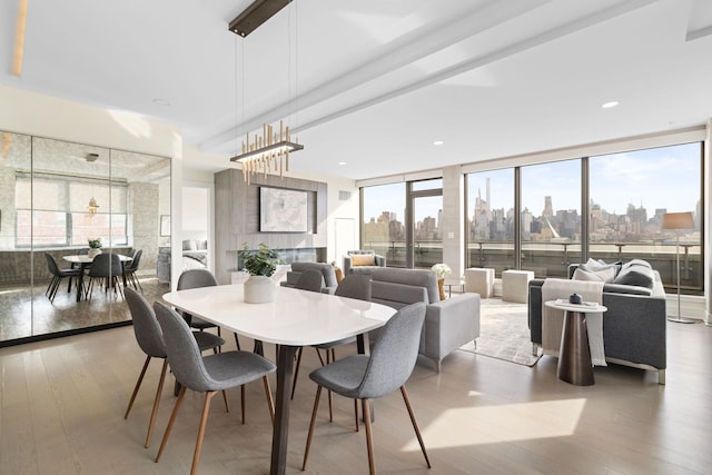 dining area featuring expansive windows, plenty of natural light, a chandelier, and hardwood / wood-style flooring