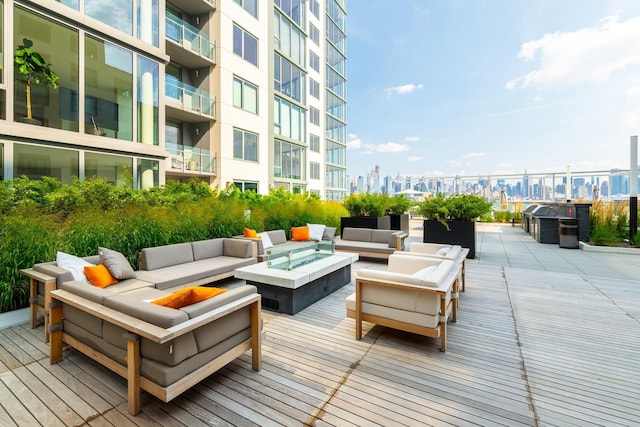 wooden deck with an outdoor living space with a fire pit and a patio