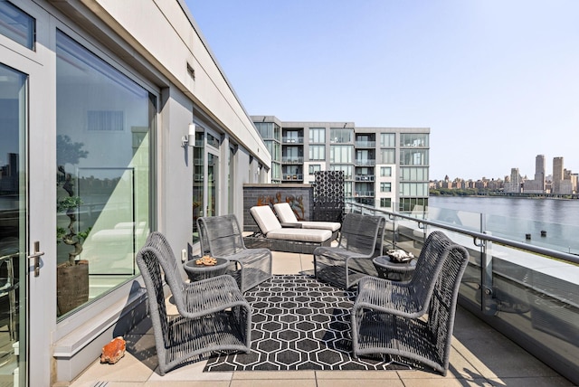 view of patio / terrace with a balcony and a water view