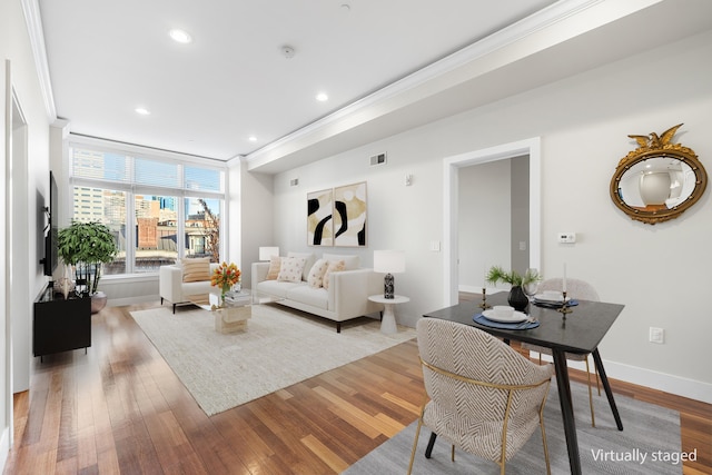 living room featuring light wood-type flooring and crown molding