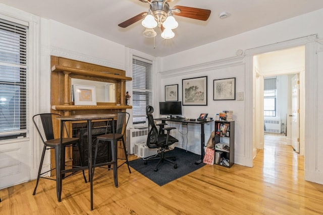 office with ceiling fan, light wood-style floors, and radiator