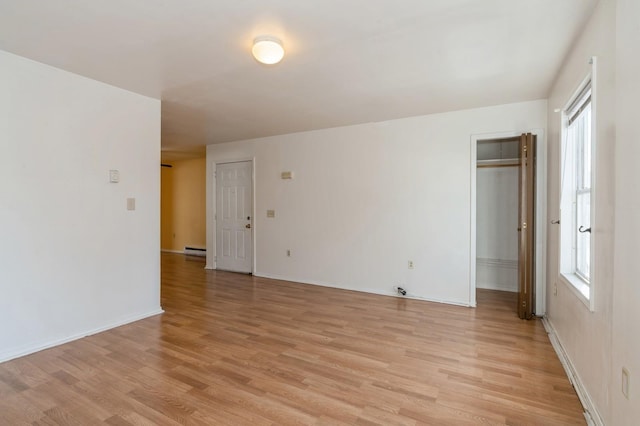 112 Astor Pl, Jersey City, NJ 07304 - spare room featuring light wood-style floors, baseboards, and a baseboard heating unit