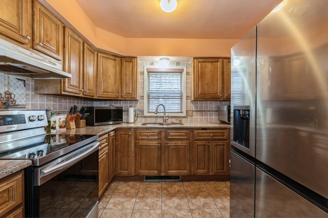 112 Astor Pl, Jersey City, NJ 07304 - kitchen featuring appliances with stainless steel finishes, a sink, brown cabinetry, backsplash, and under cabinet range hood