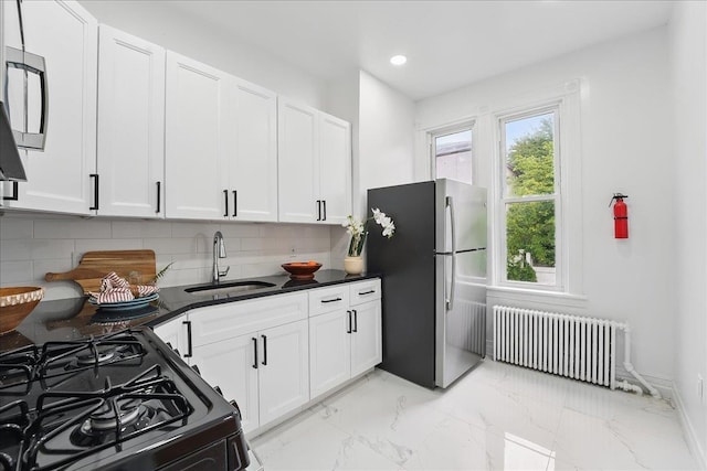 144 Nelson Ave, Jersey City, NJ 07307 - kitchen with radiator heating unit, freestanding refrigerator, a sink, black range with gas stovetop, and light marble finish floors