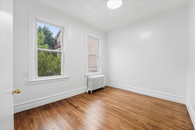 144 Nelson Ave, Jersey City, NJ 07307 - spare room with radiator, wood-type flooring, and baseboards
