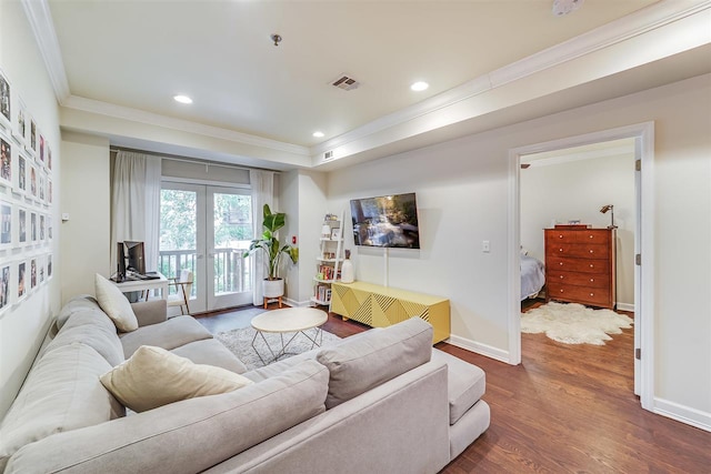 living room featuring a raised ceiling, crown molding, dark hardwood / wood-style floors, and french doors