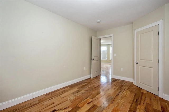 unfurnished bedroom with baseboards and light wood-style floors