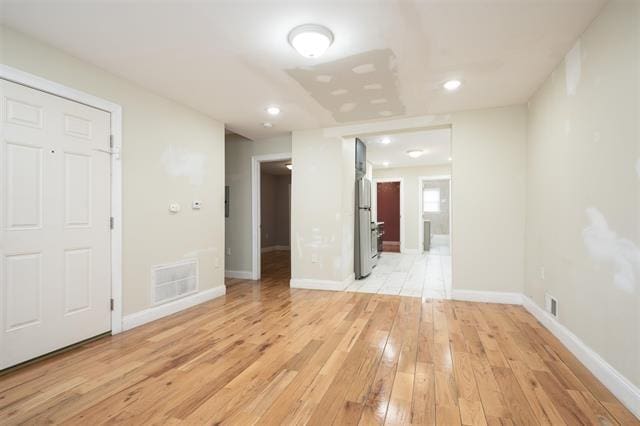 unfurnished room with visible vents, baseboards, and light wood-style floors