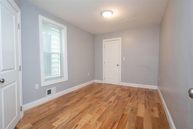 unfurnished room with visible vents, baseboards, and light wood finished floors