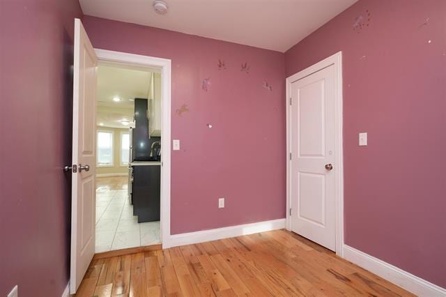 unfurnished bedroom with light wood-style floors and baseboards