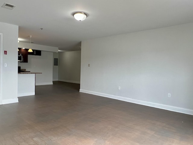 empty room featuring electric panel, visible vents, and baseboards