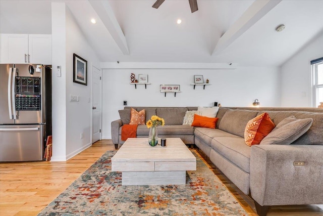 living room featuring light hardwood / wood-style flooring, ceiling fan, and vaulted ceiling